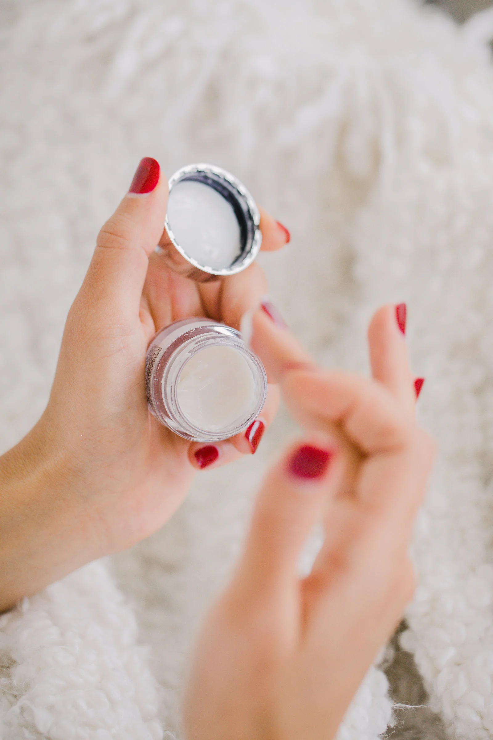 Hands holding a small cosmetics jar
